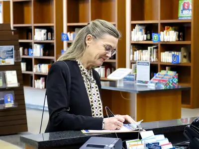 Woman signing up for a library card on a paper application
