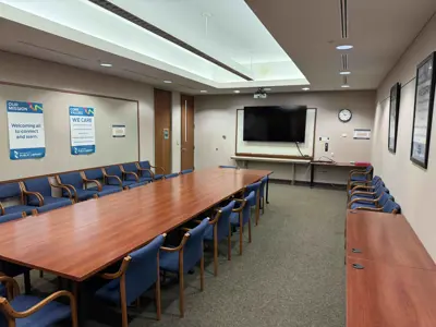 2nd floor meeting room with a long table and chairs, a wall mounted television and space for 30 people